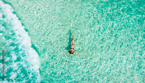 Young woman floating in the clear sea of the Mexican Caribbean. Cancun, Mexico. photo