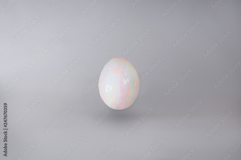 light, slightly colored egg on grey background. light, slightly colored egg on grey background.