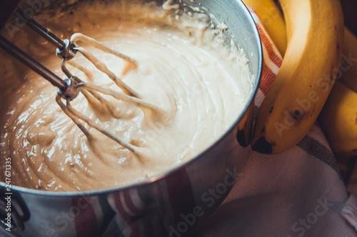 Banana Bread Batter Being Mixed In A Stainless Steel Bowl On A Wooden Table