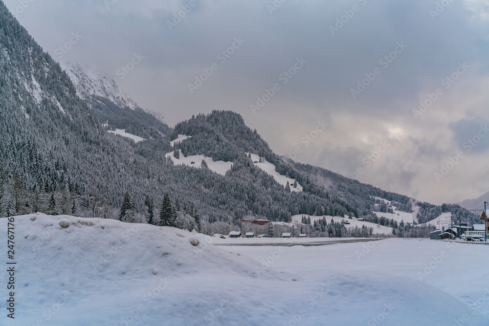 Winter evening landscape of snowy mountains in Saanen, Switzerland