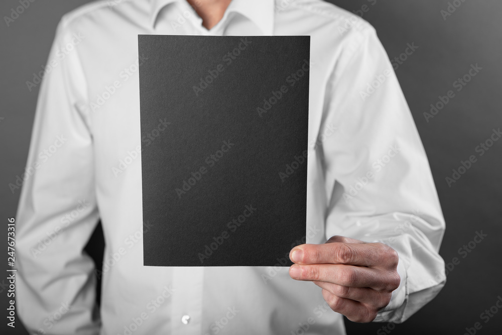 A man holding black booklet A man holding black booklet