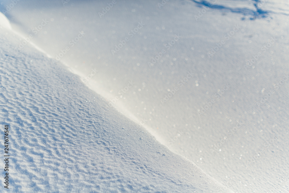 Texture of frosty snow, selective focus on left side of the frame, right side blurred/ frosty winter day, cold snap, frozen lake, little snow dunes due to the wind on the lake, copy space. Texture of frosty snow, selective focus on left side of the frame, right side blurred/ frosty winter day, cold snap, frozen lake, little snow dunes due to the wind on the lake, copy space.