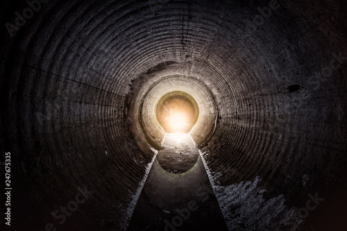 Wall Mural Flooded round underground drainage sewer tunnel with dirty sewage water