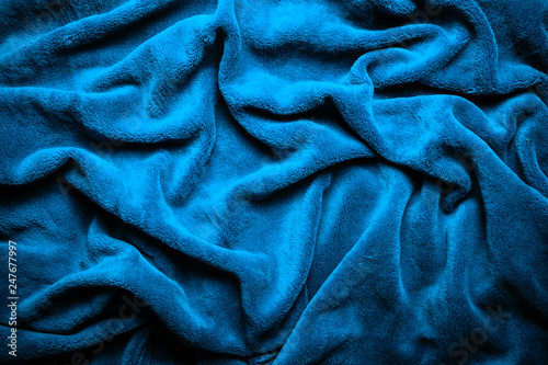 Winkled plush canvas texture.. Wavy soft blue blanket background. 