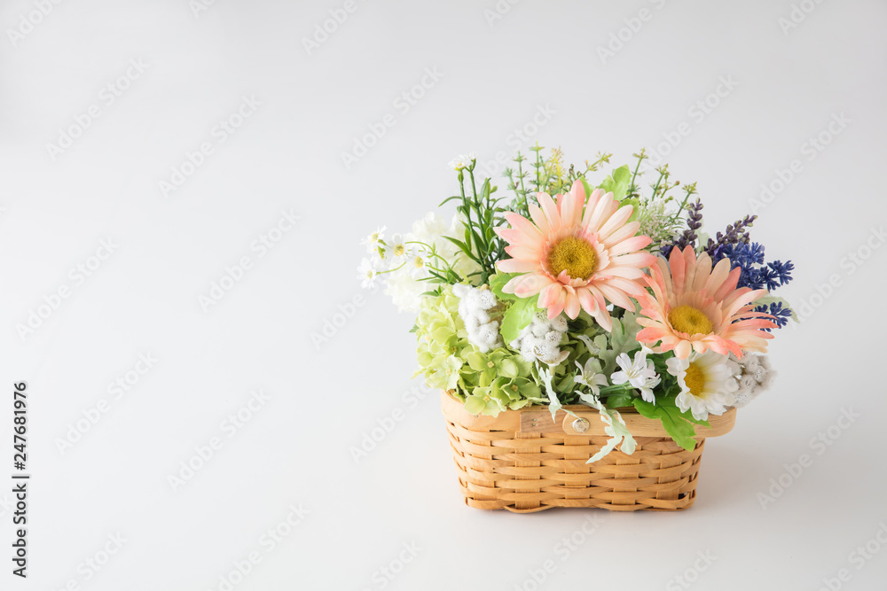 白い背景に花屋に売っていそうなカゴにたくさんの花をつめた花束