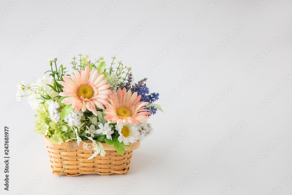Fototapeta premium 白い背景に花屋に売っていそうなカゴにたくさんの花をつめた花束