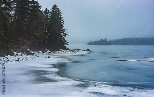 Winter lake shoreline on a misty day in Halifax, Nova Scotia, frozen, foggy.