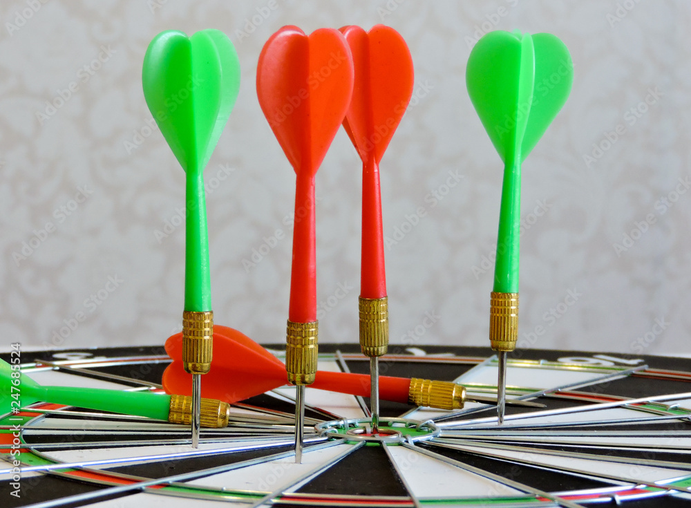 Dart arrow hitting in the target center of dartboard. Success hitting target aim goal achievement concept background.Darts and dart board.Close up shot of the dart arrow.Marketing concept. Dartboard. Dart arrow hitting in the target center of dartboard. Success hitting target aim goal achievement concept background.Darts and dart board.Close up shot of the dart arrow.Marketing concept. Dartboard.