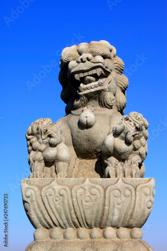stone lion on bridge railing, China