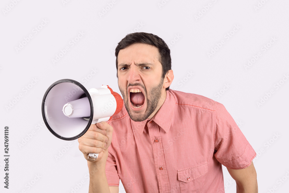 Young man screaming on a megaphone. Young man screaming on a megaphone.