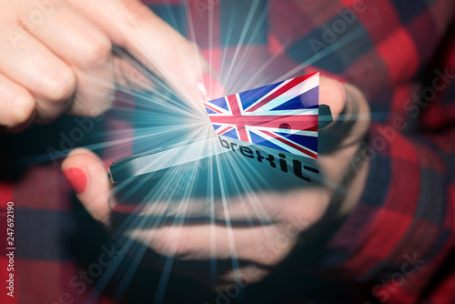 Eine Frau mit Smartphone, Flagge von Großbritannien und Brexit