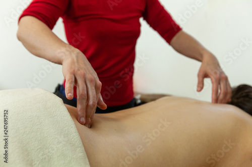 Woman's hands giving a massage. Close up of woman's hands massaging the shoulder of a woman, in a professional environment