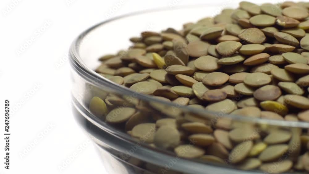 Lentils. Rotation. Close up. Heap of raw uncooked brown lentils in a bowl in rotation. Food background. Isolated on white, studio shot. Healthy organic food diet concept Lentils. Rotation. Close up. Heap of raw uncooked brown lentils in a bowl in rotation. Food background. Isolated on white, studio shot. Healthy organic food diet concept