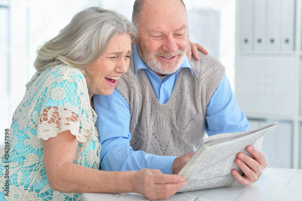Portrait of senior couple reading newspaper at home Portrait of senior couple reading newspaper at home