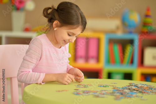 Portrait of girl collecting puzzles at home