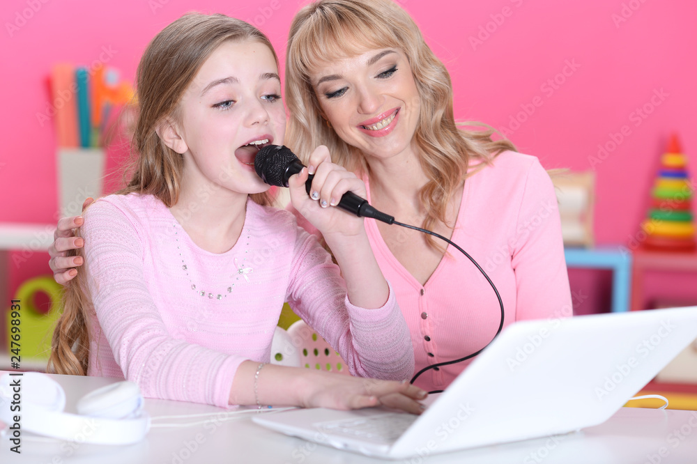 cute girl sitting at table and singing karaoke cute girl sitting at table and singing karaoke