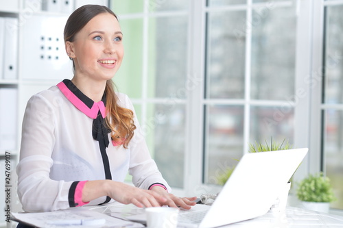 Portrait of young beautiful woman working in office