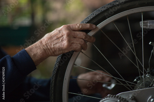 Hands of Senior Man Working on Bicycle