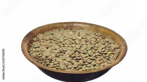 Lentils. Rotation. Close up. Heap of raw uncooked brown lentils in a bowl in rotation.  Food background.  Isolated on white, studio shot. Healthy organic food diet concept