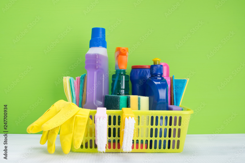 on the table, on a green background is a basket with a set of tools for disinfection and cleaning on the table, on a green background is a basket with a set of tools for disinfection and cleaning