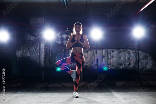 Asian Tan Skin Fitness woman exercise Stretch arms legs warm up Smoke Dark background environment, studio lighting rim back light copy space, concept Women Can Do Sport 6 packs © Jade