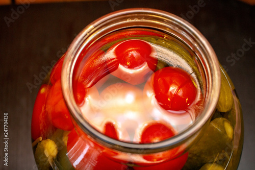 Pickles in the glass jar on the wooden table