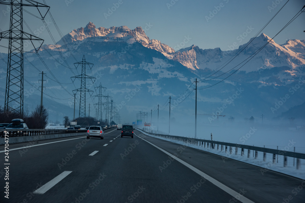 Schweizer Autobahn mit Gebirge bei Sonnenuntergang
