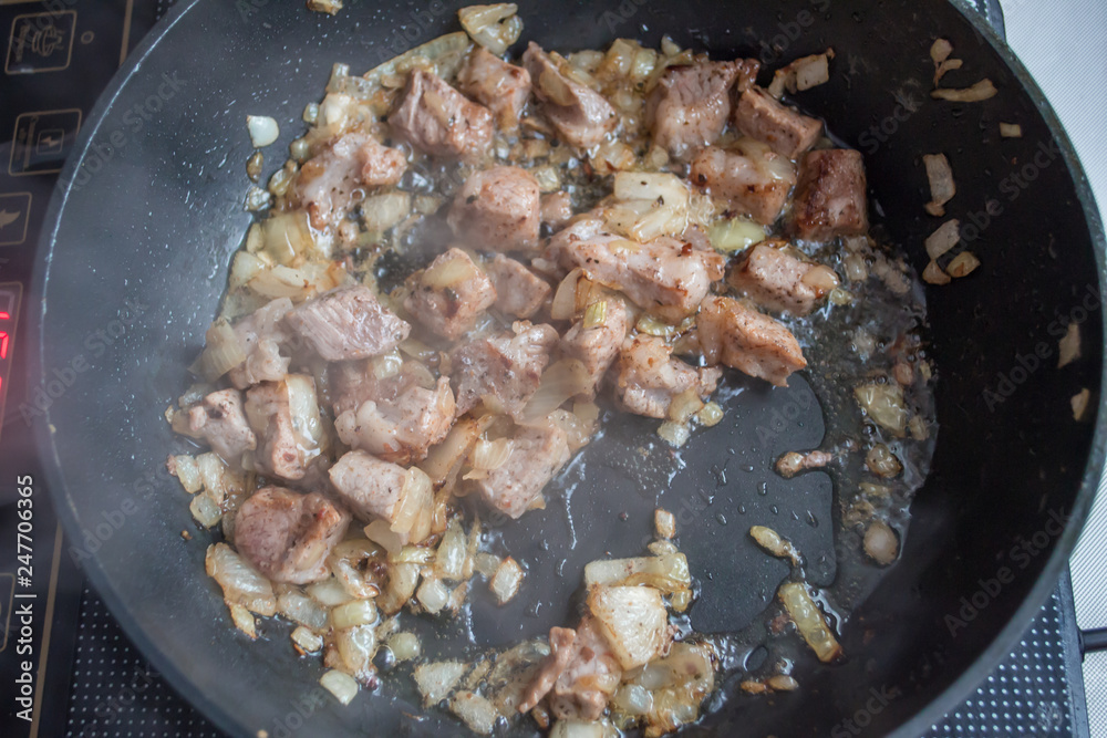 Food preparation. Cooking pork on the pan. Fried pork with onion. Fresh fried pork prepared at home. Food preparation. Cooking pork on the pan. Fried pork with onion. Fresh fried pork prepared at home.