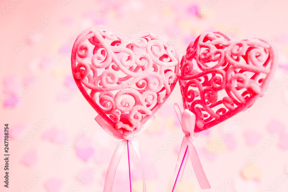 Close-up of two pink hearts on a blue background, selective focus