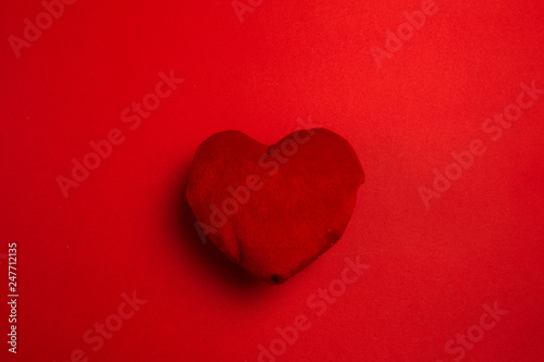 red soft heart on red background.
