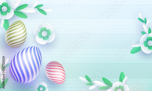 Top view of colorful easter eggs and paper cut flowers on blue stripe background.