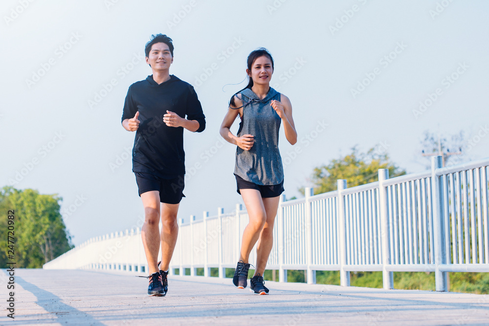 Obraz premium young couple runner running on running road in city park