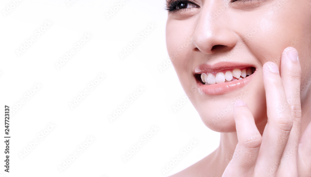 Obraz premium Close up Smiling young woman touching skin or applying cream isolated on white background. Asian happy girl looking at something. Skin care face healthy young women in studio white.