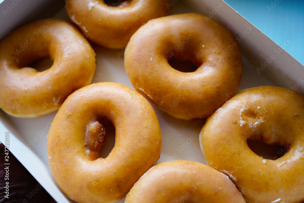 A dozen of Golden glazed Doughnuts in the box A dozen of Golden glazed Doughnuts in the box