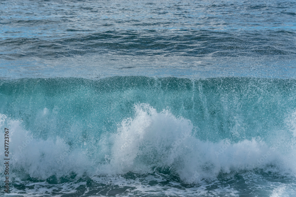 Turquoise Blue Wave Breaking and Washing into Shore in Italy