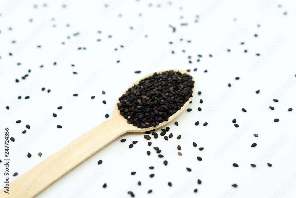 Black sesame on wooden spoon isolated on white background. Black sesame on wooden spoon isolated on white background.