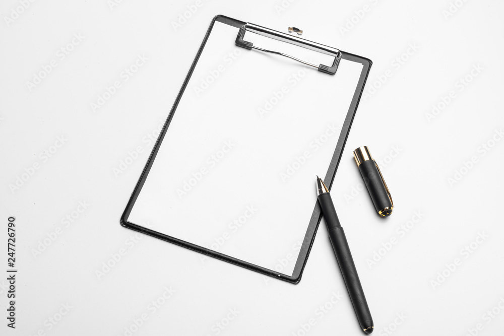 Clipboard with white sheet and pen isolated on a white background. Top view Clipboard with white sheet and pen isolated on a white background. Top view