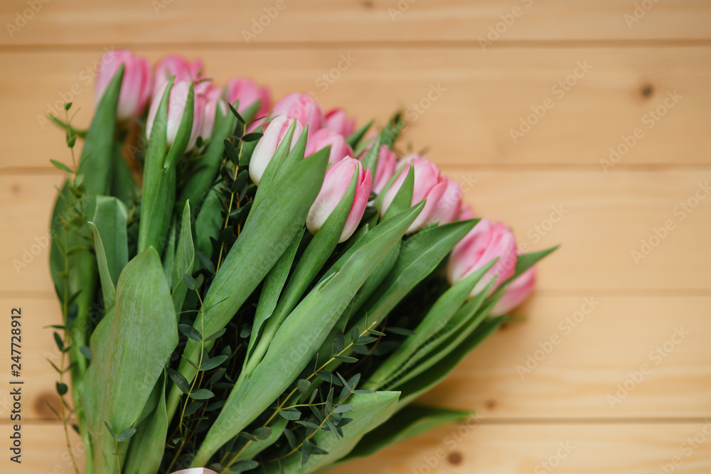 Bouquet of bright pink tulips with a beautiful bow on a wooden background Bouquet of bright pink tulips with a beautiful bow on a wooden background