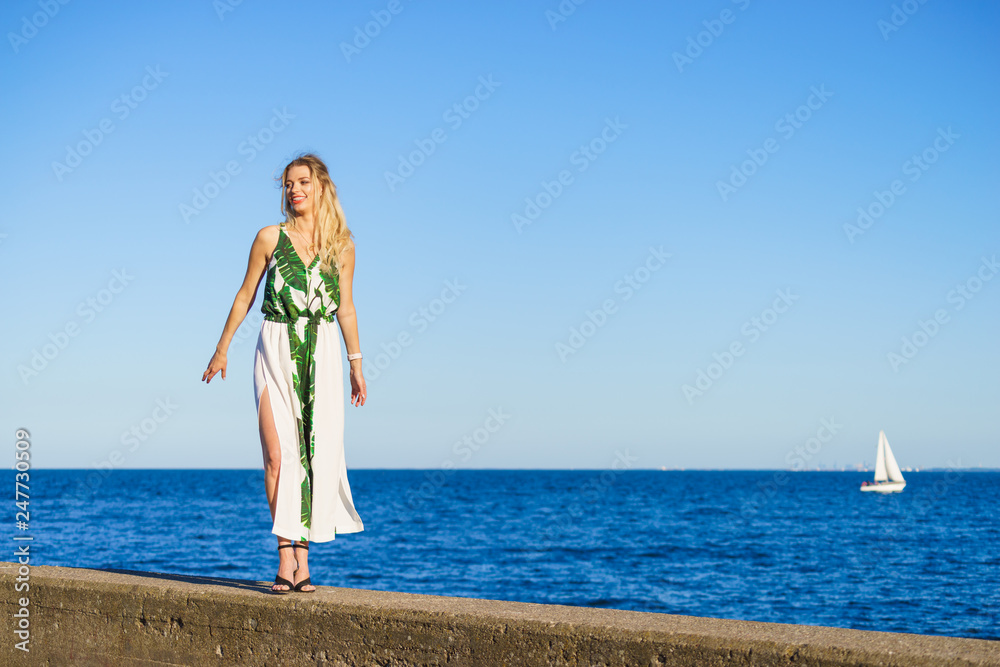 Woman in summer long dress against sea