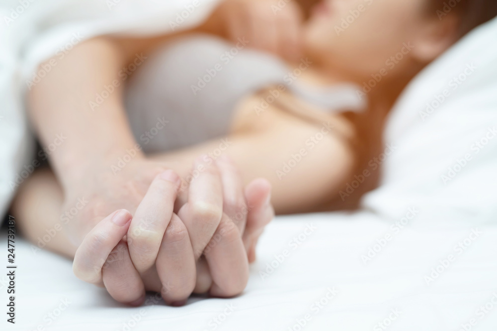 Feeling on hands of passion couple having sex. two Lovers couple Holding hands under blanket white sheets on the bed with lust and making love. concept having sexual romantic moments. Feeling on hands of passion couple having sex. two Lovers couple Holding hands under blanket white sheets on the bed with lust and making love. concept having sexual romantic moments.