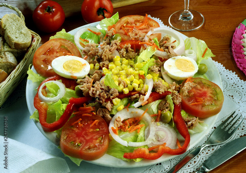 Plato con una ensalada de lechuga, tomate, pimiento, cebolla, zanahoria, maiz, aceitunas, Huevo hervido y atún.