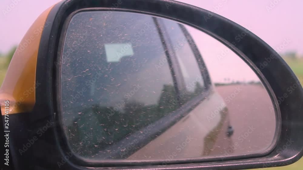 Side view mirror reflection of two-lane winding road in forest. View through the window while traveling. Spring summer background. Stock video Side view mirror reflection of two-lane winding road in forest. View through the window while traveling. Spring summer background. Stock video