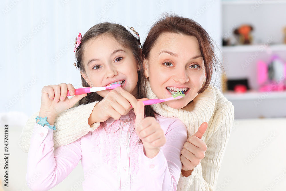 mom and daughter brushing their teeth.photo with copy space mom and daughter brushing their teeth.photo with copy space