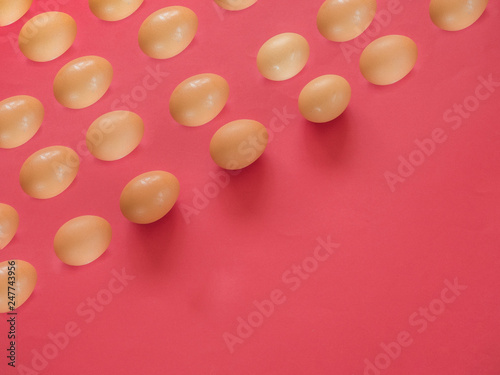 Brown eggs pattern on red background with copy space