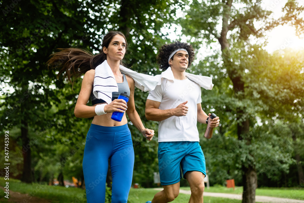 Obraz premium Happy young woman doing excercise outdoor in a park, jogging