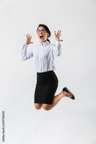 Full length portrait of a pretty businesswoman jumping