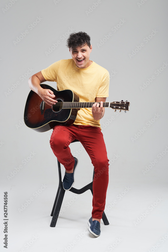 Acoustic Guitarist On Stool