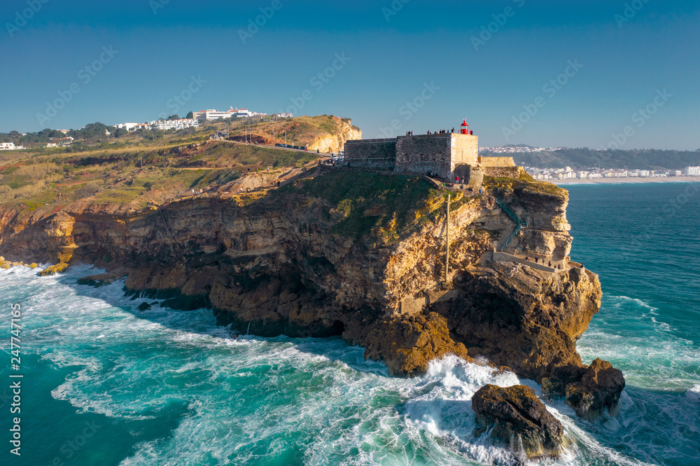 Foto Stock Aerial; drone flight near Farol de Nazare, sighseeing of  Portugal; a place where some of the biggest waves form | Adobe Stock