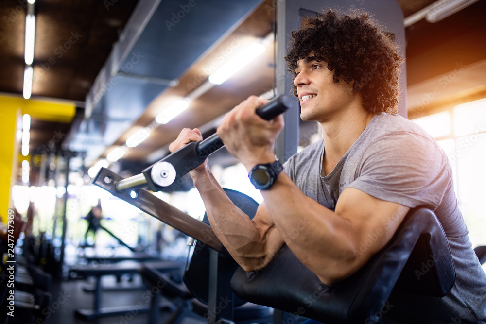 Young fit handsome man doing exercises in gym Young fit handsome man doing exercises in gym