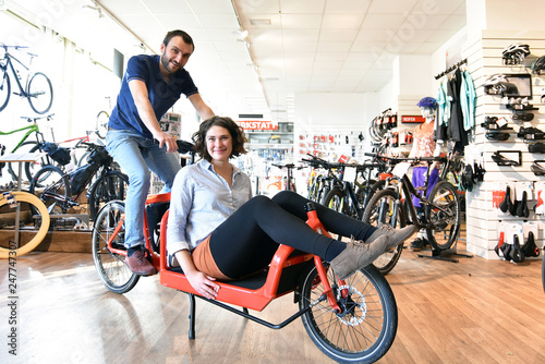 customer and dealer in bicycle shop - purchase and repair of bicycles - couple testet a transport bicycle
